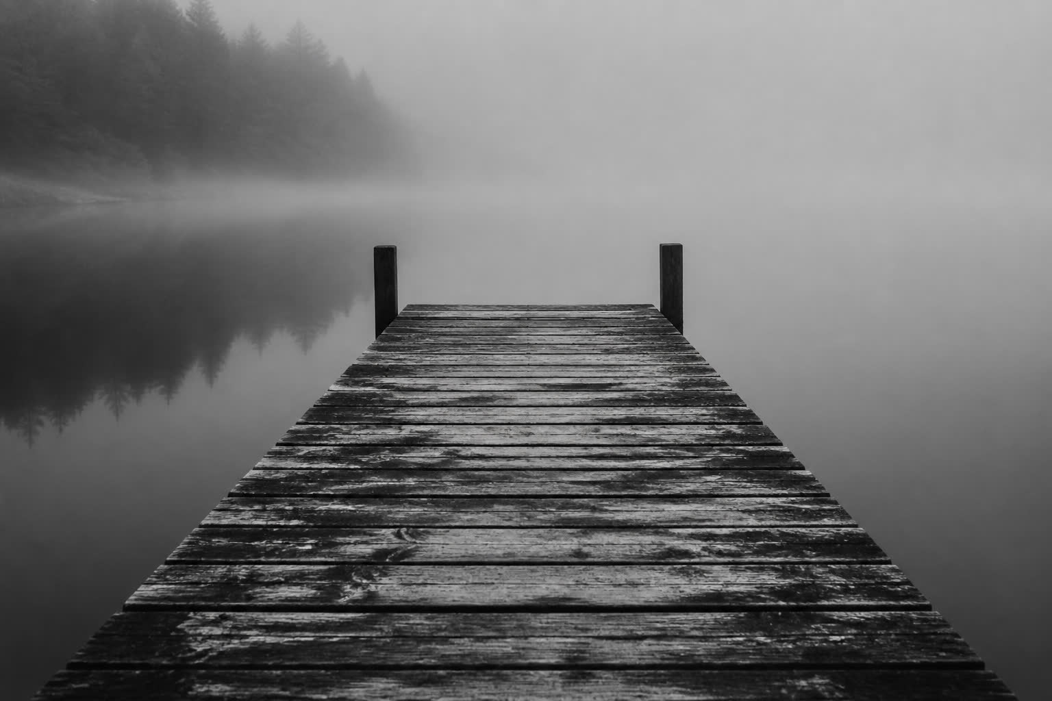 Black-and-white empty wooden dock over still water